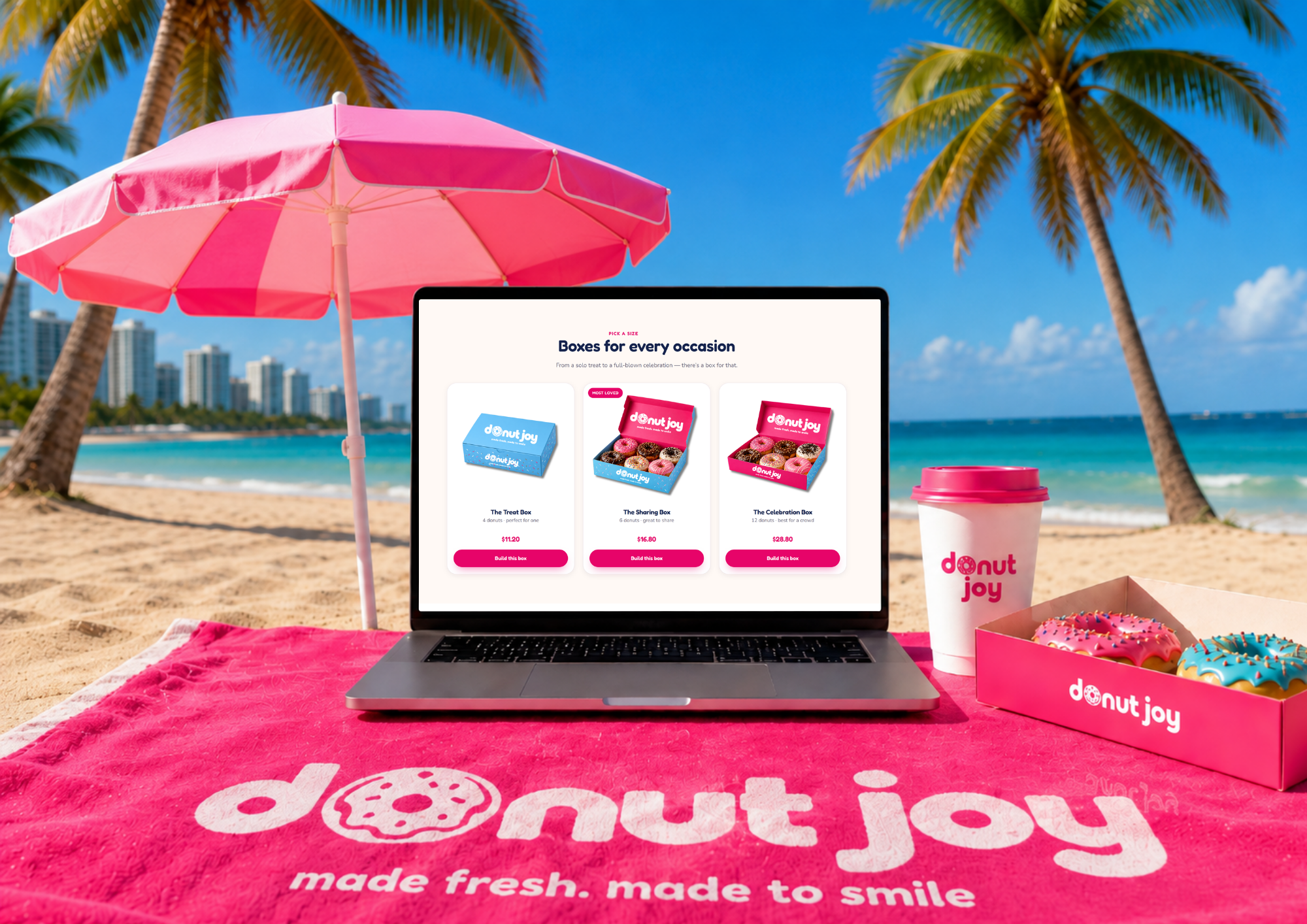 The Donut Joy box-size page on a laptop on a branded beach towel